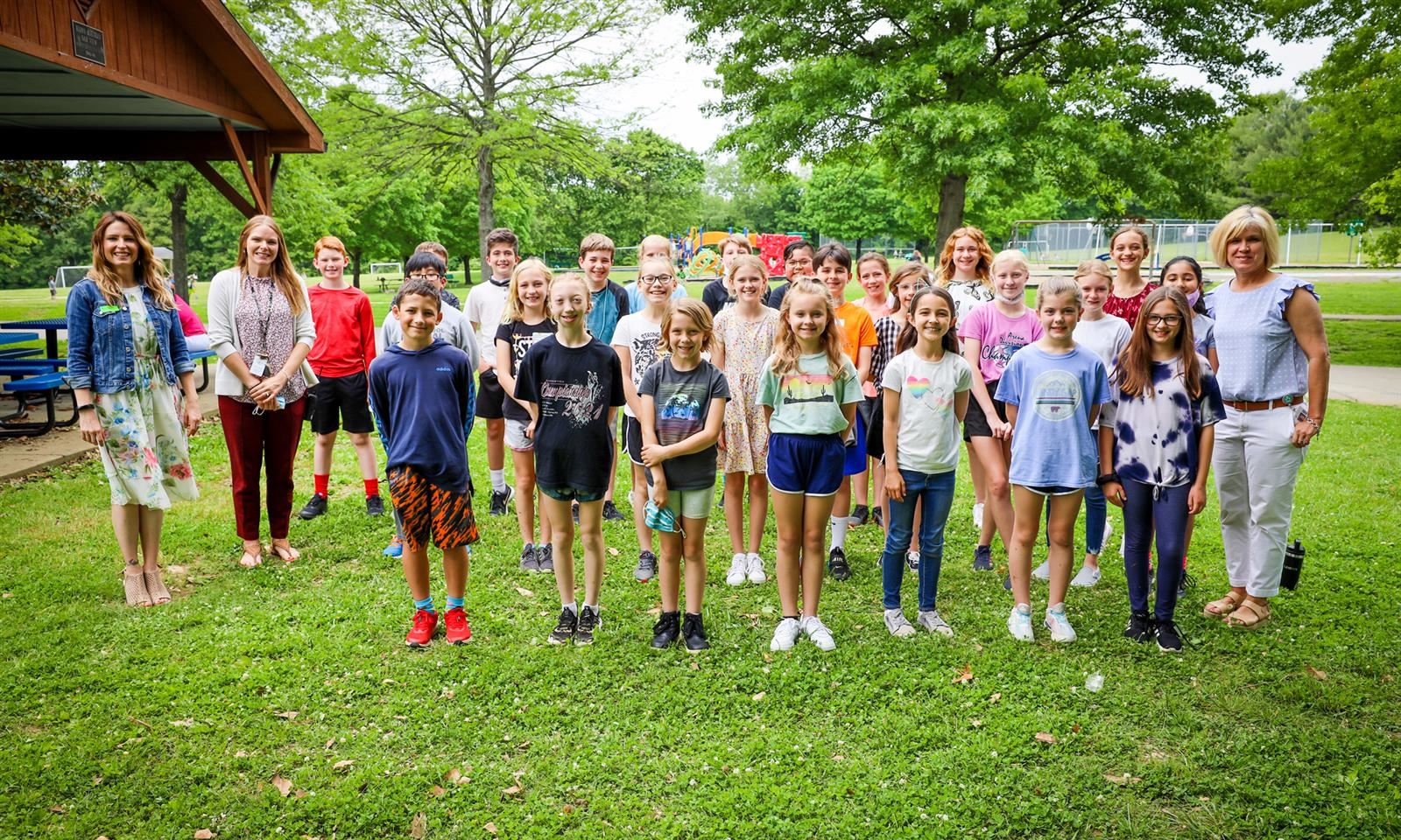 Students stand in a group and smile